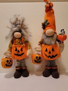 two scarecrows dressed in halloween costumes with jack - o'- lantern pumpkins