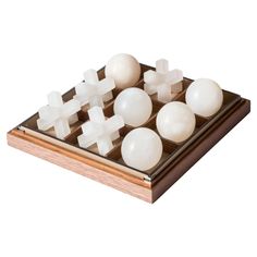 a wooden board game set with white balls and crosses on the top, all in different sizes