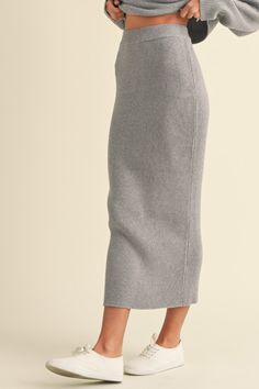 Cyrus Skirt Heather grey ribbed knit midi skirt. Elastic waistband Fitted A matching set with the Cyrus Sweater Viscose/Poly Blend | Model is wearing a Small