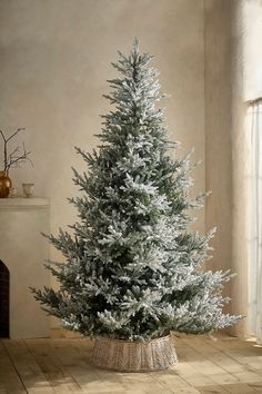 a white christmas tree in a basket on the floor