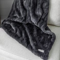 a black blanket sitting on top of a white couch