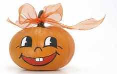 an orange pumpkin with a bow on it's head and eyes painted to look like a smiley face