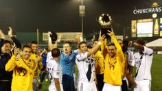 the soccer players are celebrating with their trophy