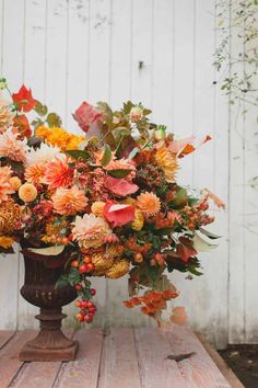 a vase filled with flowers sitting on top of a wooden table