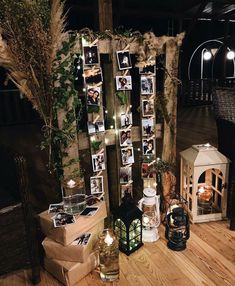 an arrangement of candles and pictures on display in a room with wood flooring at night