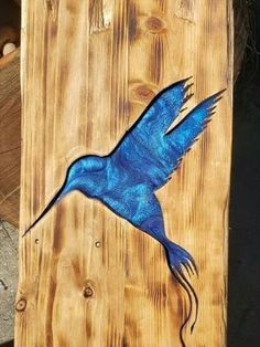 a blue bird painted on a wooden plank