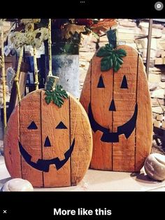 two carved pumpkins sitting next to each other on top of a wooden table with the caption more like this