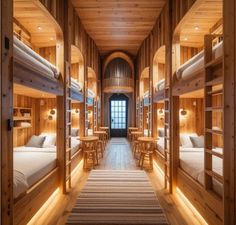 bunk beds are lined up in the middle of a room with wooden walls and flooring