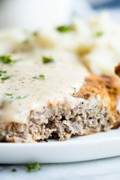 a piece of meatloaf covered in gravy on a plate