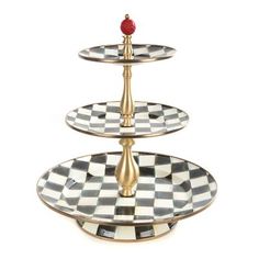 three tiered cake stand with a red rose on top and checkered plates below