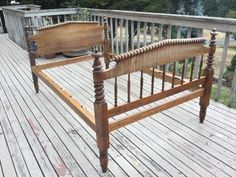 a wooden bed sitting on top of a wooden deck