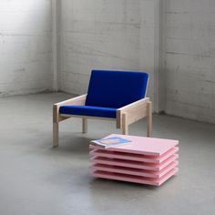 a stack of pink and blue chairs sitting next to each other in a white room