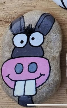 a rock with a cartoon cow painted on it