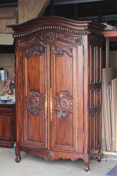 a large wooden armoire sitting inside of a room