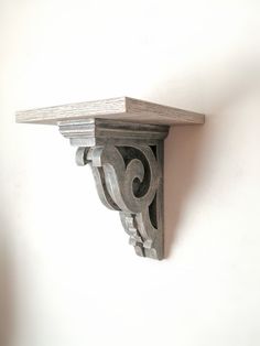 the corner of a shelf is made out of wood and has an ornate design on it