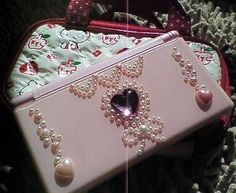 a pink purse with pearls and a heart on it