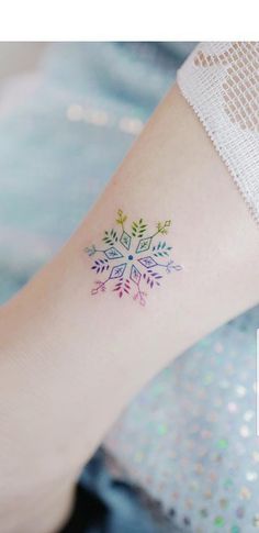 a person with a tattoo on their arm and the words snowflake written below it