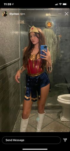 a woman in a costume taking a selfie with her cell phone while standing next to a shower