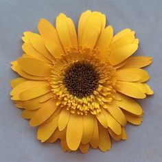 a large yellow flower sitting on top of a table