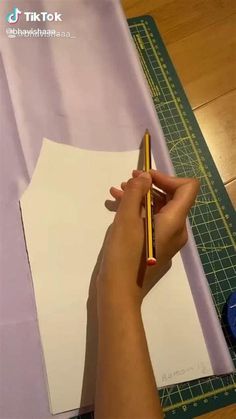 someone is cutting out paper with a pencil