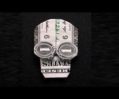 a money origami mask with the words survive on it's face and two dollar bills sticking out of its mouth