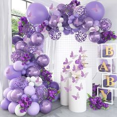 purple and white balloons are hanging from the ceiling