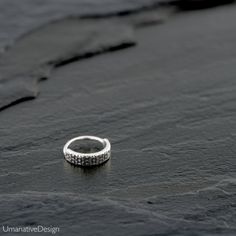 a diamond ring sitting on top of a black surface