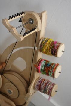 a weaving machine with several spools of thread on the front and back of it