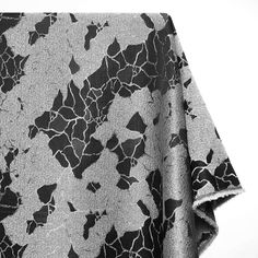 a black and white photo of a blanket on top of a tablecloth with an abstract design