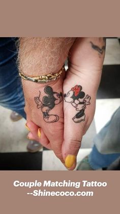 two people holding hands with tattoos on them