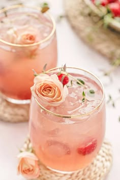 two glasses filled with pink liquid and flowers