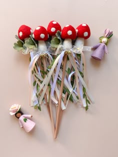 a group of mushrooms sitting on top of a table next to small doll figurines