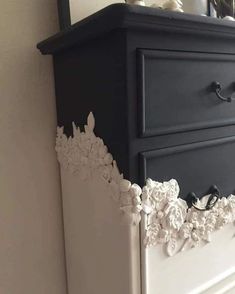 a black and white dresser with flowers on it