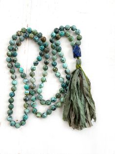 "African Turquoise and Lapis Lazuli Mala - 108 Beads - Hand Knotted - 8mm length approx. 39\" - 6mm length approx. 32\" A Mala to keep negative energy away and encourage honesty of the spirit and new possibilities. Made from African Turquoise Jasper beads hand knotted into a 108 bead Mala. This Mala is used for growth and develop positive change and awakens the soul to its intended purpose. A faceted Lapis Lazuli Guru bead is a nice focal point for this Mala. Lapis is known as the stone of truth Green Bohemian Necklace With 8mm Beads, Bohemian Faceted Meditation Beads, Green 8mm Bohemian Beads, Bohemian Green 8mm Beads, Blue Bohemian Hand Knotted Necklaces, Blue Bohemian Hand-knotted Necklaces, Spiritual Turquoise Beaded Necklaces With Faceted Beads, Green Chrysocolla Beaded Necklaces With Round Beads, Green Chrysocolla Beaded Necklaces