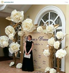 a woman standing in front of a backdrop with white roses on it and the words ann is shown