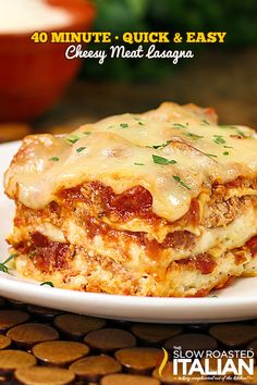 a white plate topped with lasagna covered in sauce and cheese on top of it