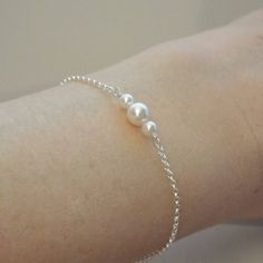 Delicate Pearl Bracelet- Bridesmaid Gifts- Wedding Jewelry- FREE SHIPPING A cute and dainty bracelet featuring a trio of pearls. The two smaller pearls are 4mm and the center pearl is 6mm. They are a lovely creamy white and are all Swarovski. The chain is a very sturdy, high quality rolo and closes with a classic spring style clasp. Each bracelet comes packaged in a small jewelry box tied with ribbon. Pearl White Bracelet Jewelry As Bridesmaid Gift, Classic Silver Pearl Bracelet For Bridesmaids, Wedding Sterling Silver Round Pearl Bracelet, Delicate Silver Pearl Bracelet, Hypoallergenic Beaded Bracelets For Weddings, Minimalist Sterling Silver Pearl Bracelet For Wedding, Hypoallergenic Beaded Bracelet For Weddings, Silver Dainty Pearl Bracelet For Bridesmaid, Dainty Silver Pearl Bracelet For Bridesmaid Gift