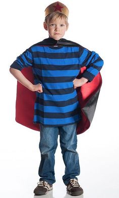 a little boy dressed up as a super hero with his cape around his neck and hands on his hips