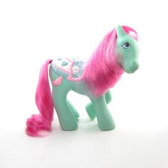 a toy pony with pink hair and blue eyes on a white background in front of the camera