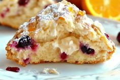 a close up of a piece of cake on a plate with cranberries and oranges in the background