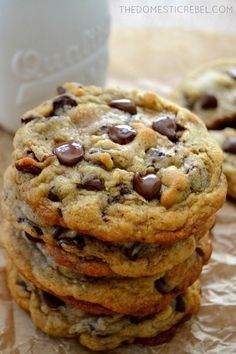 chocolate chip cookies stacked on top of each other next to a cup of coffee and paper