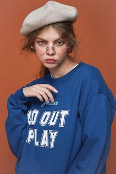 a woman with glasses and a hat on top of her head wearing a sweatshirt that says go out play