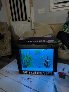 a person sitting on a couch in front of a box with a happy valentine's day message