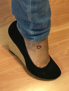 a person with a small heart tattoo on their ankle