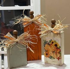 two vases decorated with sunflowers are sitting on a table next to each other