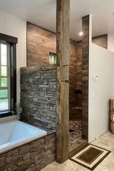 a large bathroom with stone walls and tile flooring, along with a tub in the corner