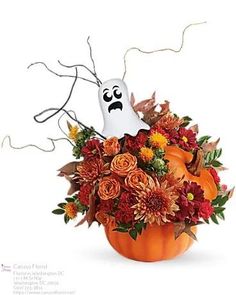 a pumpkin decorated with flowers and a ghost