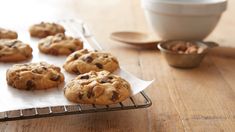 chocolate chip cookies cooling on a baking rack next to a bowl of oatmeal