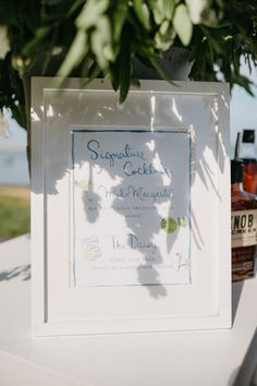 a sign that is sitting on top of a table next to some bottles and flowers