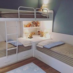 two bunk beds in a room with white walls and wooden flooring, built into the ceiling